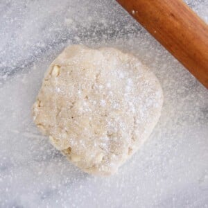 pie dough dusted with flour on marble.