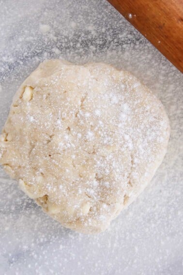pie dough dusted with flour on marble.