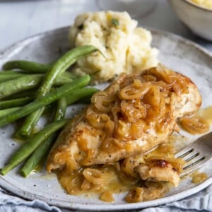 Baked Chicken and Shallots on plate with green beans and mashed potatoes