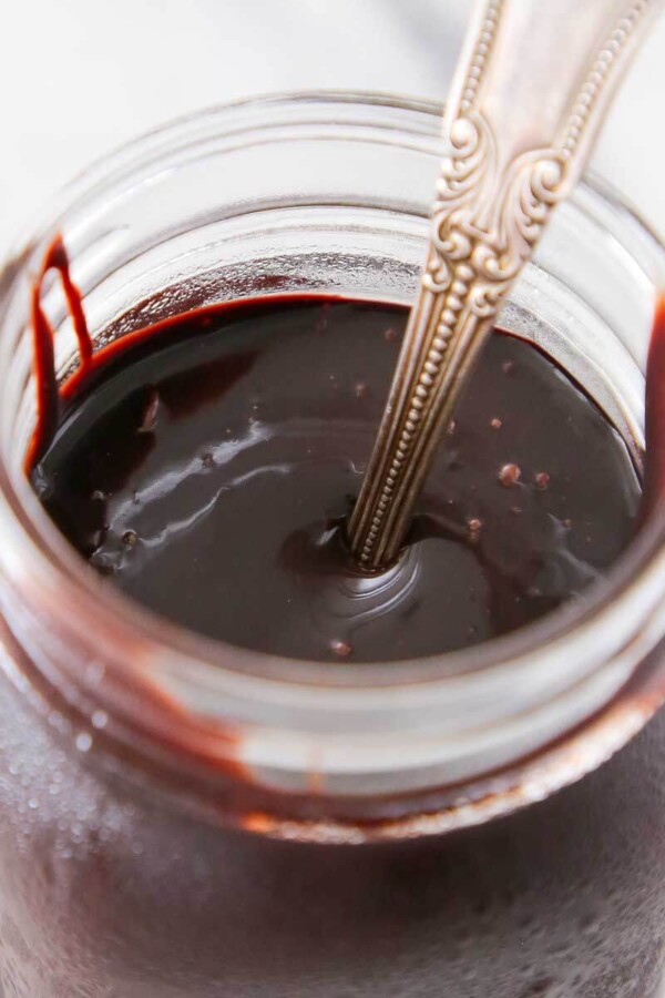 chocolate fudge sauce in jar on marble.