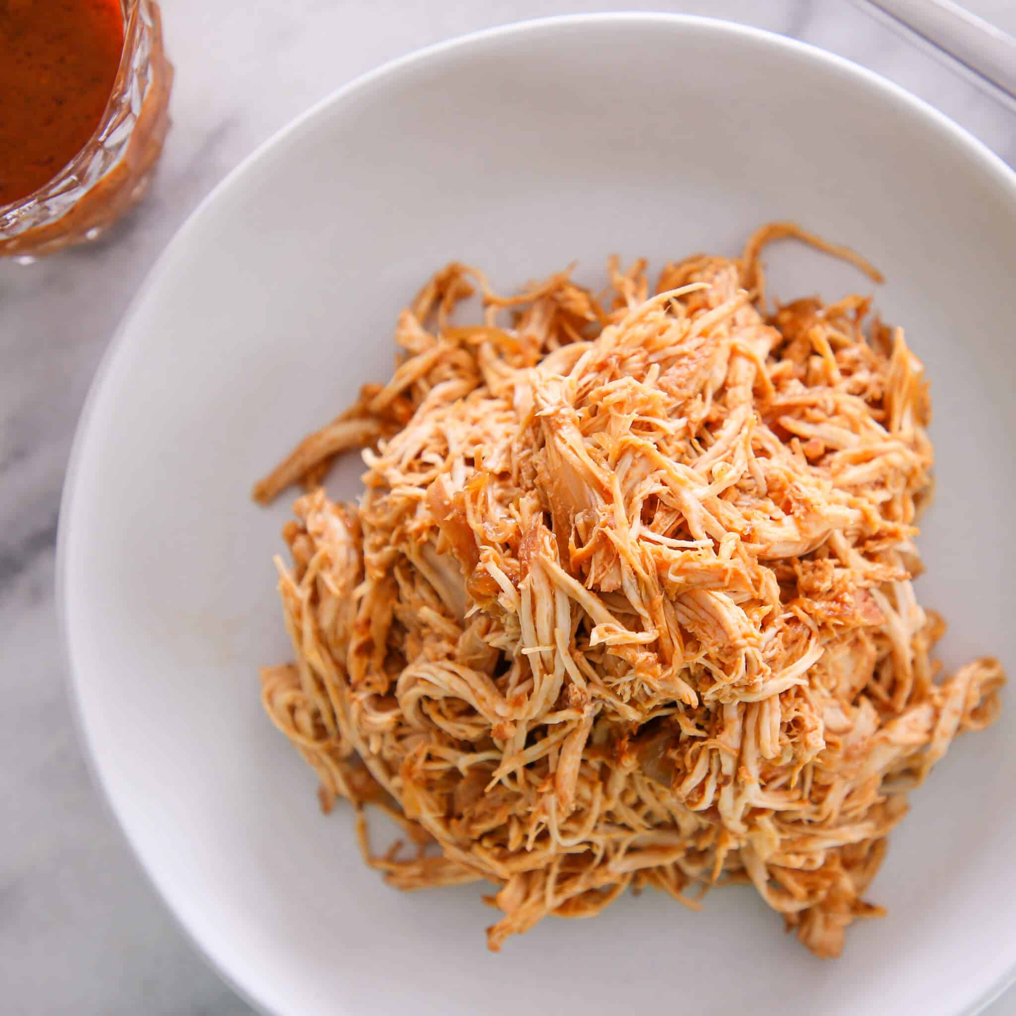 Slow cooker barbecue pulled chicken in white bowl