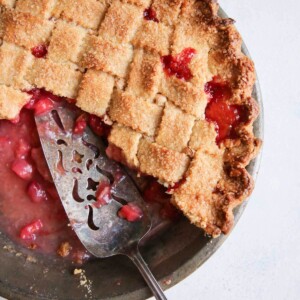 sliced and served strawberry rhubarb pie in metal tin.