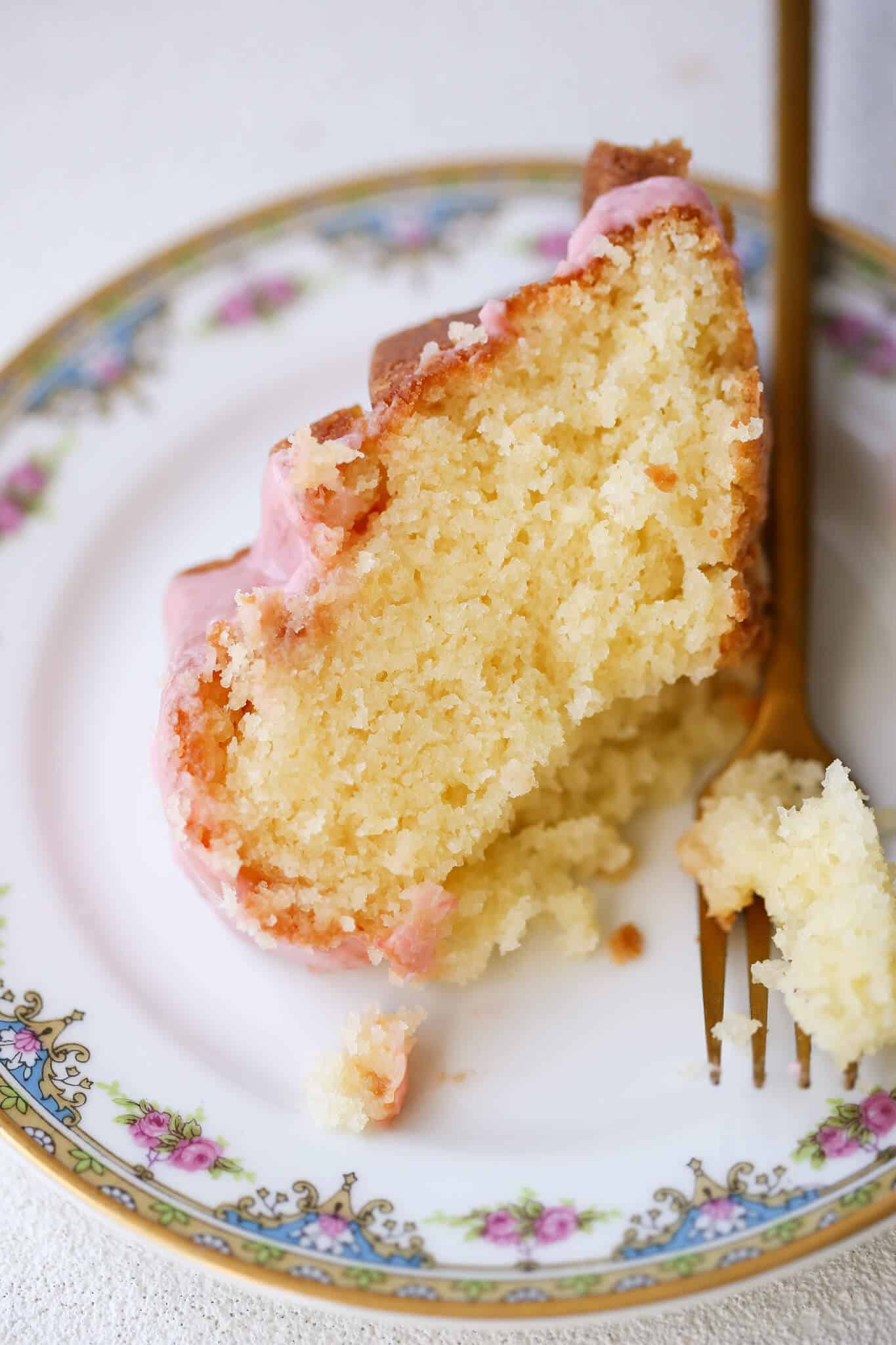 Lemon Pound Cake Strawberry Icing on china plate with gold fork.