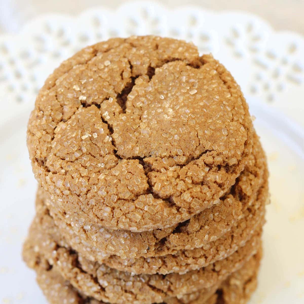 Molasses Spice Cookies stacked on white lace plate.