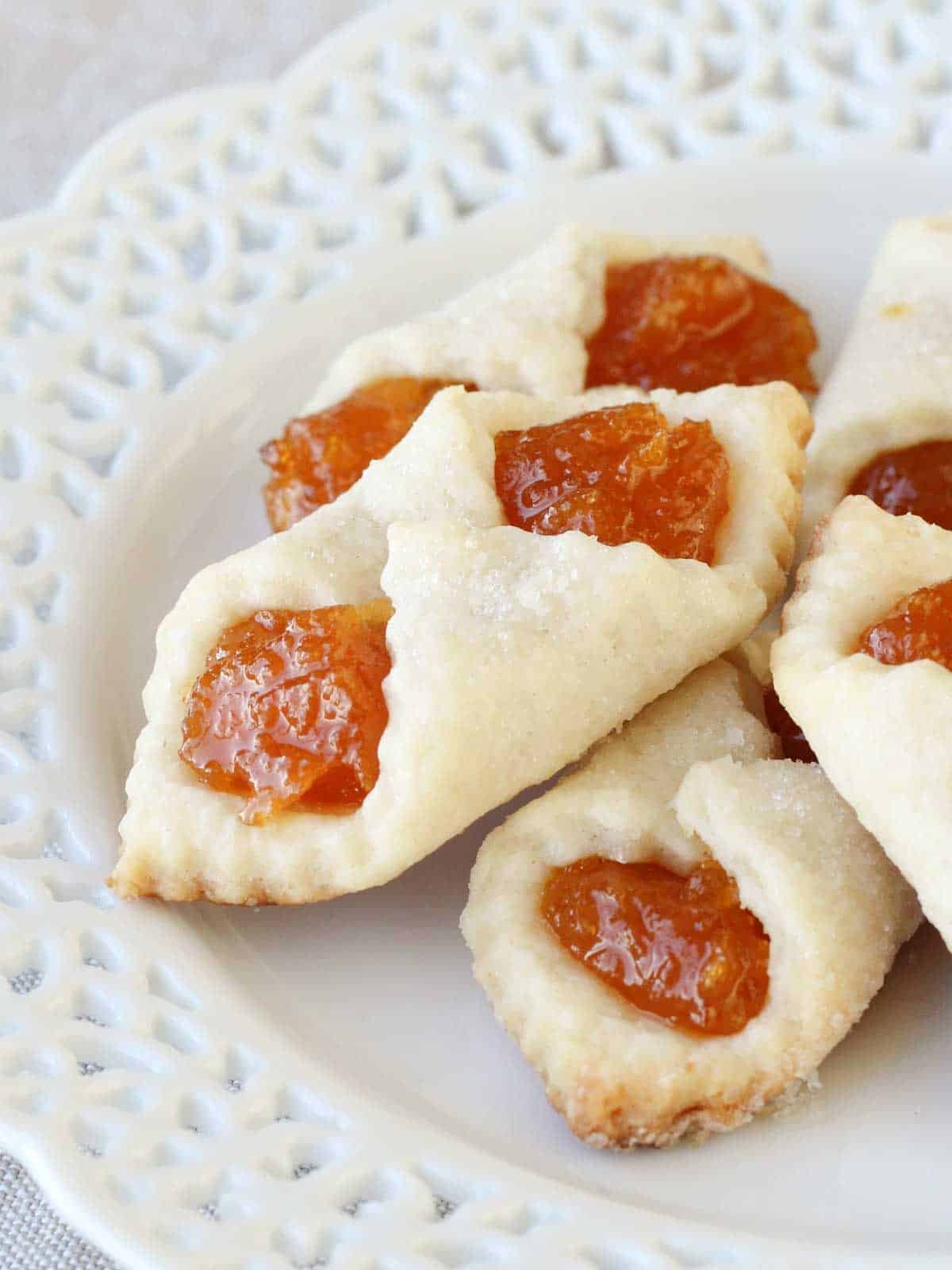 apricot kolacky cookies stacked on white lace plate. 