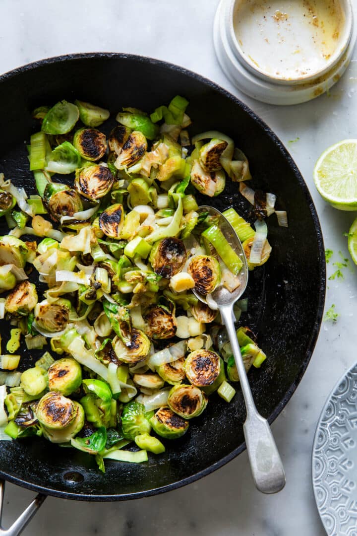 Brussels Sprouts and Leeks with Lime ginger butter in skillet with spoon
