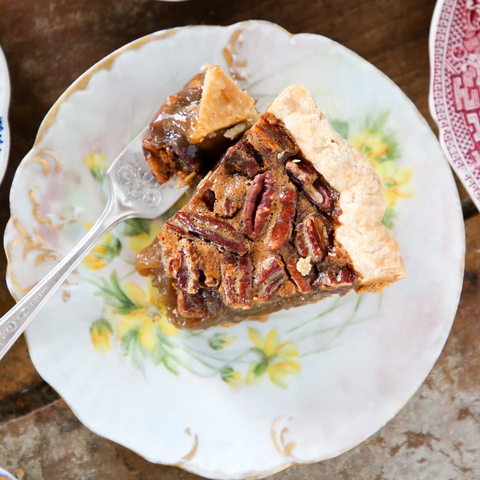 Classic Pecan Pie slice on plate with yellow flowers