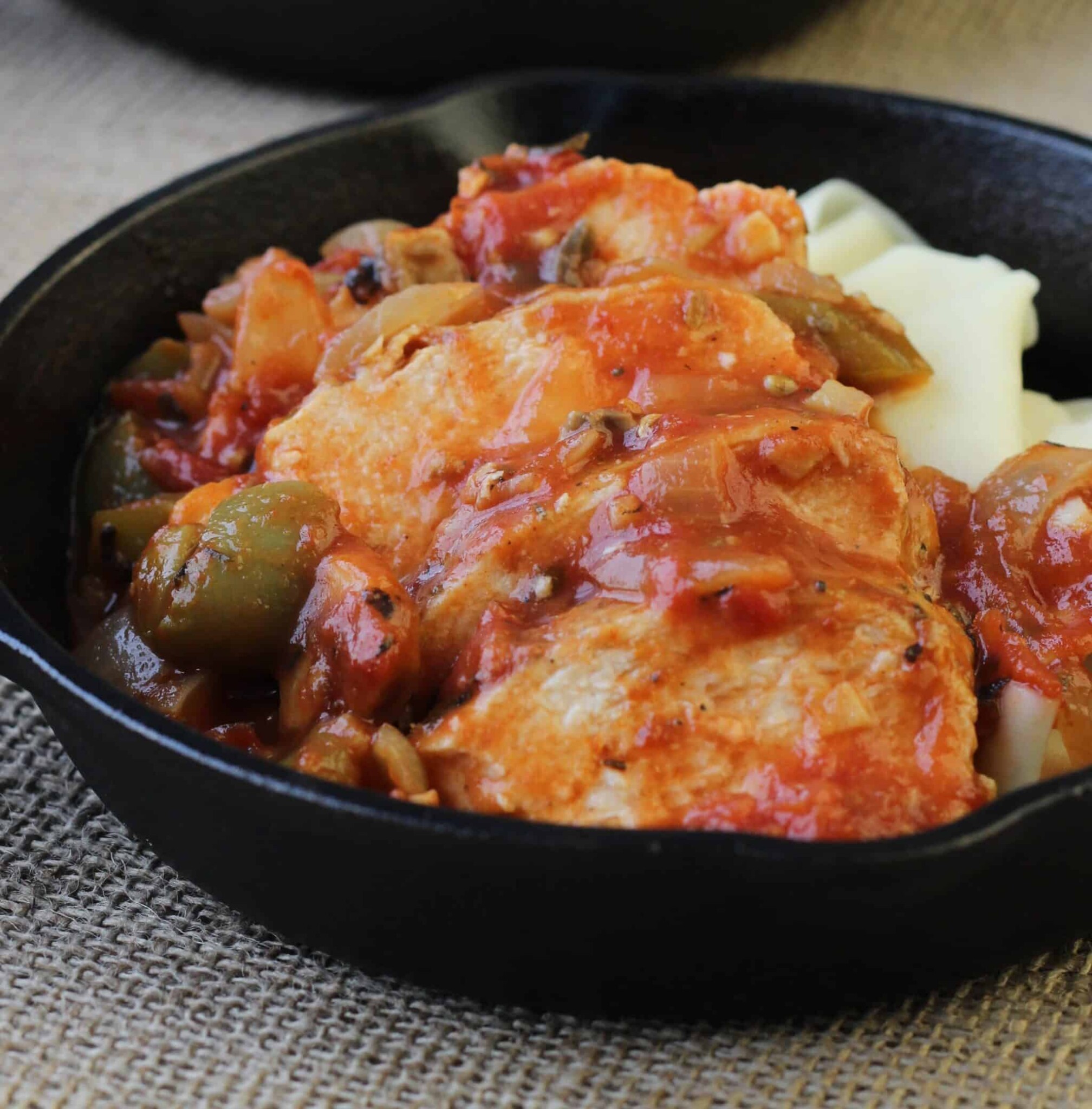 Chicken in red sauce with slices of cheese.