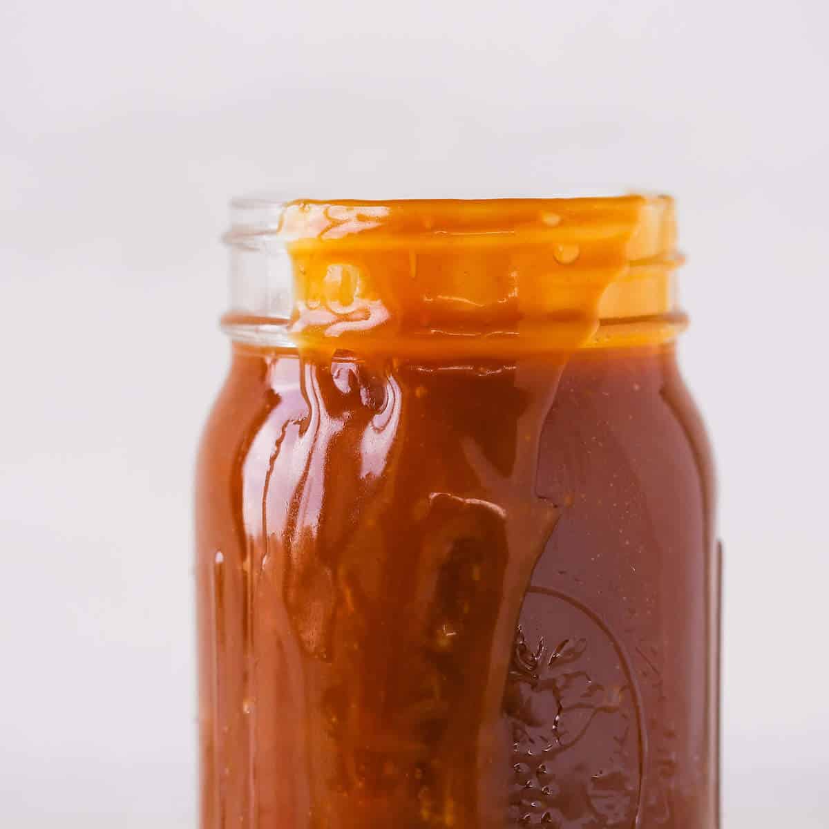 caramel sauce spilling over side of jar.