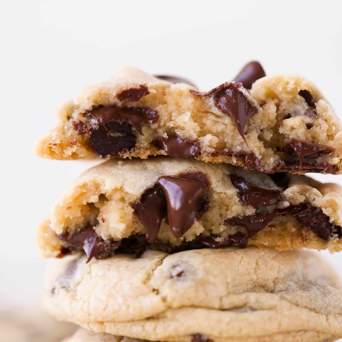 Two chocolate chip cookies stacked with gooey chocolate chips.