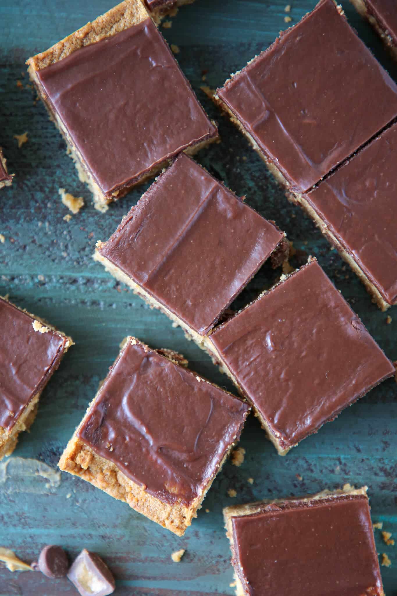 Fudgy Peanut Butter Reeses Chocolate Bars cut on turquoise surface