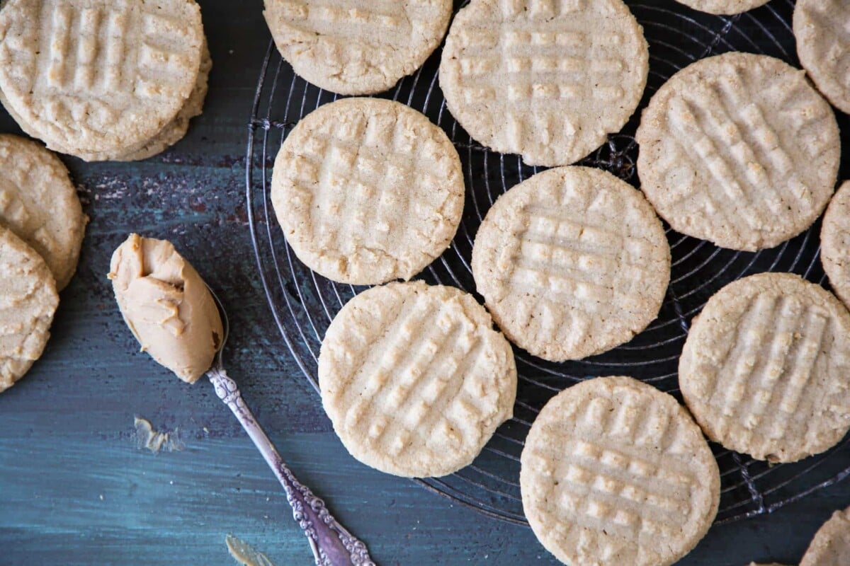 A group of old fashioned peanut butter cookies on a vintage cooling rack.