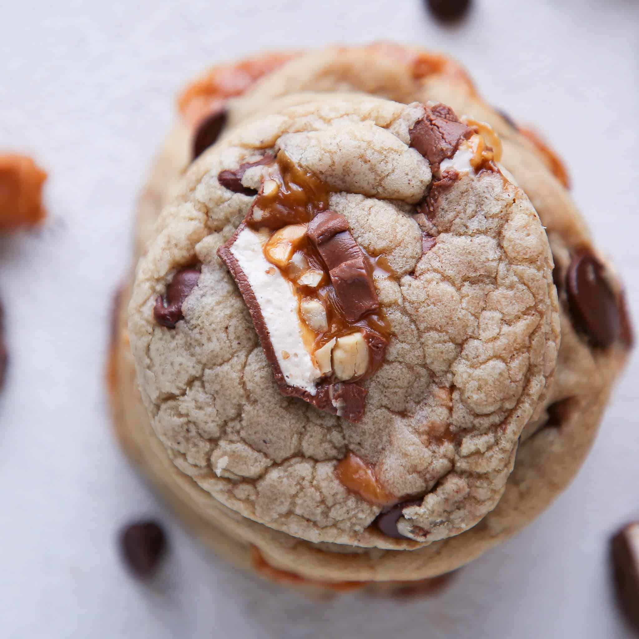 Caramel Stuffed Brown Butter Snickers Chocolate Chip Cookies stacked