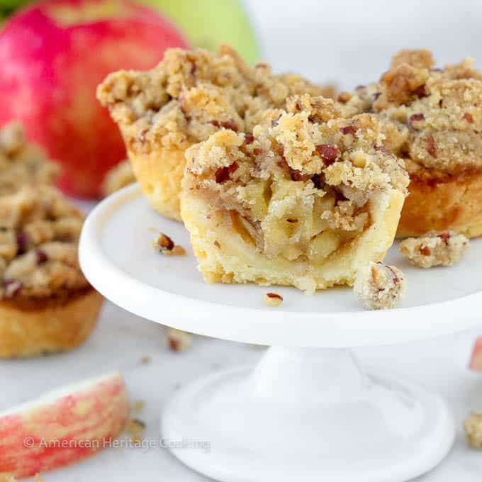 mini apple pie with crumble topping cut in half to view inside. 