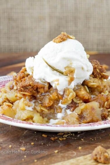 Brown sugar apple crisp with generous amount of streusel topping on red plate.