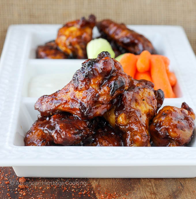 Plated chicken wings with a side of carrots on a white plate.