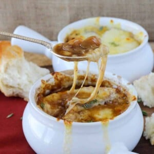 Melted cheese pulled out of French onion soup by a spoon.