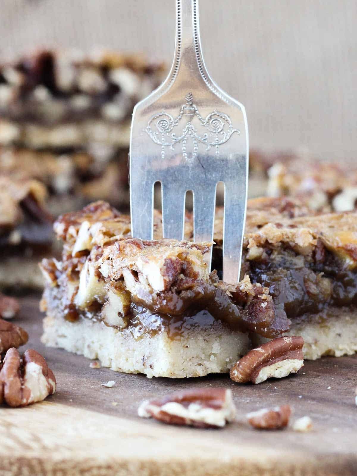 pecan pie bar with fork in taking a bite.