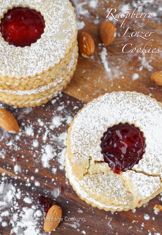 Circular linzer cookies on a wooden background.