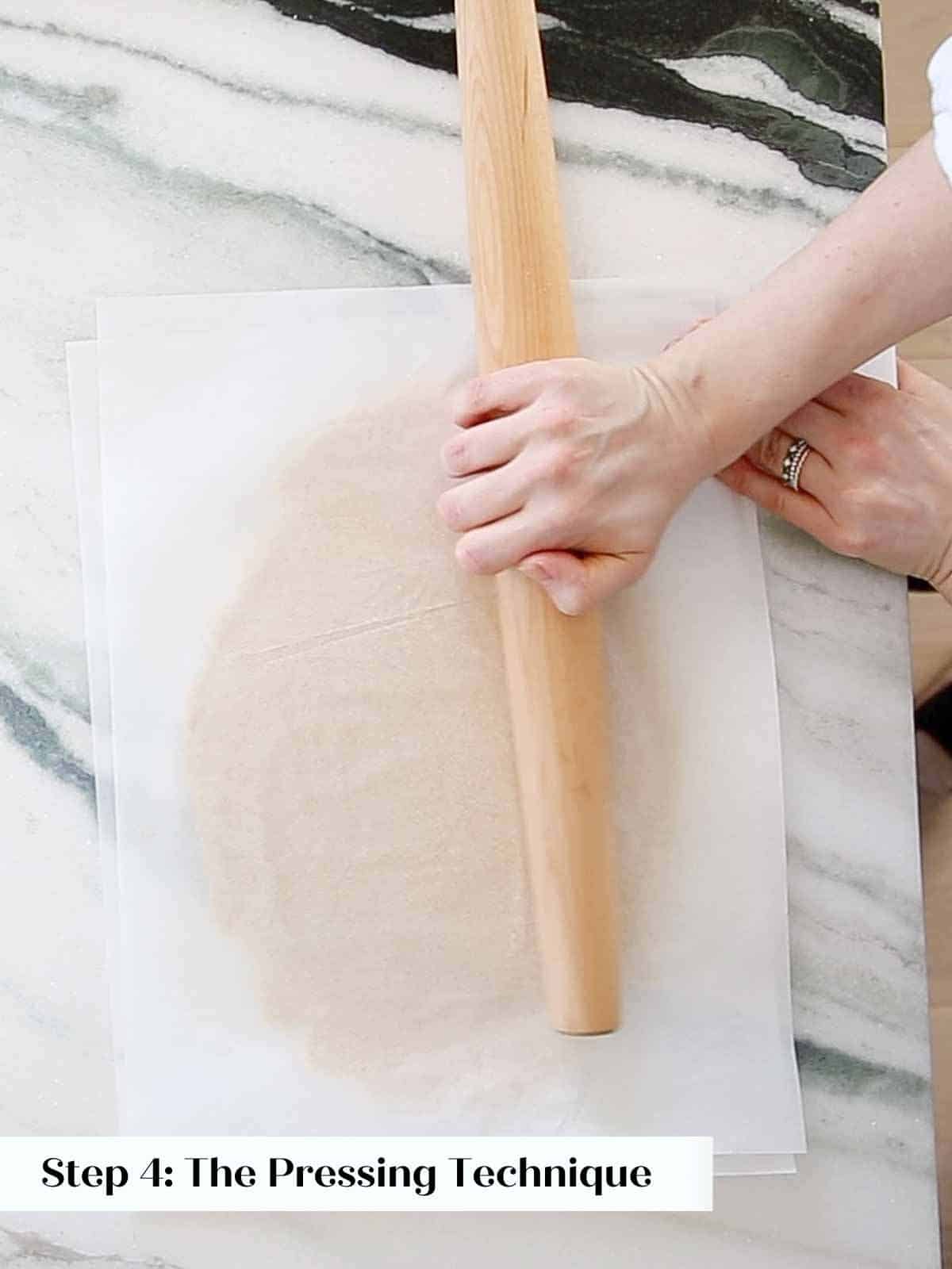 pressing dough with rolling pin to smooth and flatten. 