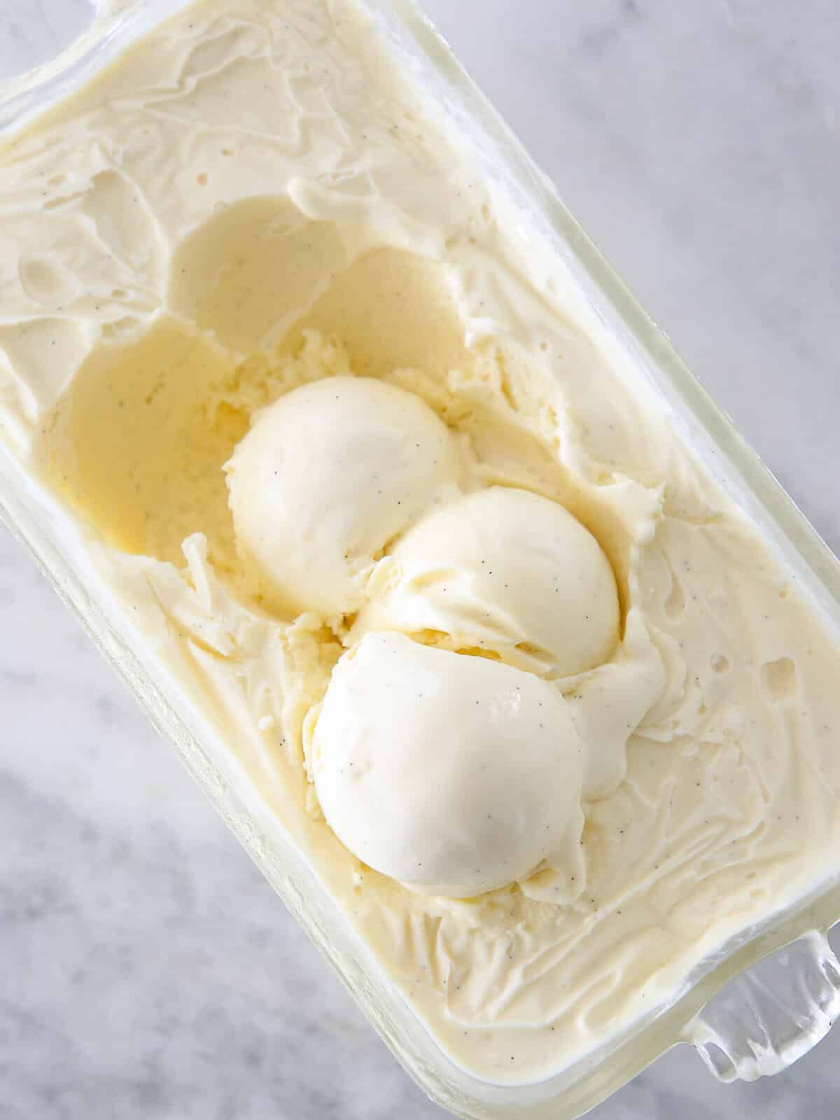 three scoops of vanilla ice cream in container.