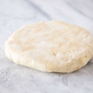 pie dough in disk on marble.