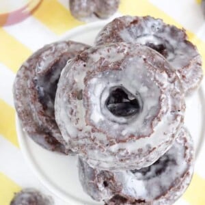 Chocolate cake donuts on a yellow surface.