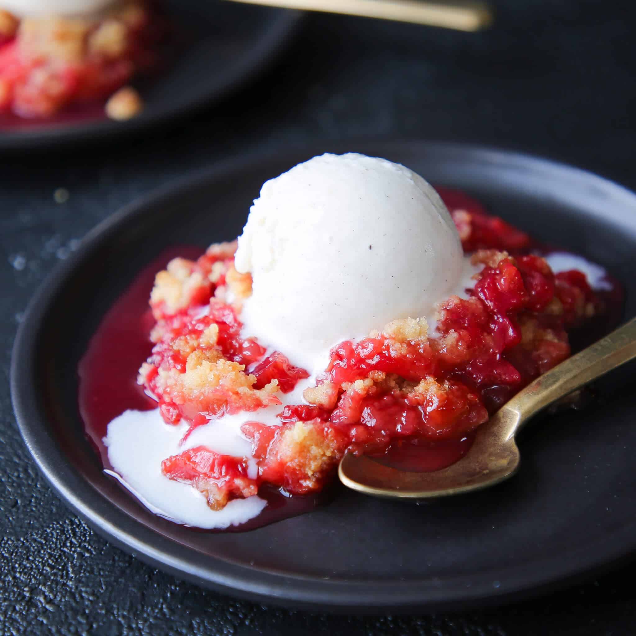 Grandmas Raspberry Rhubarb Crumble on plate with ice cream side view