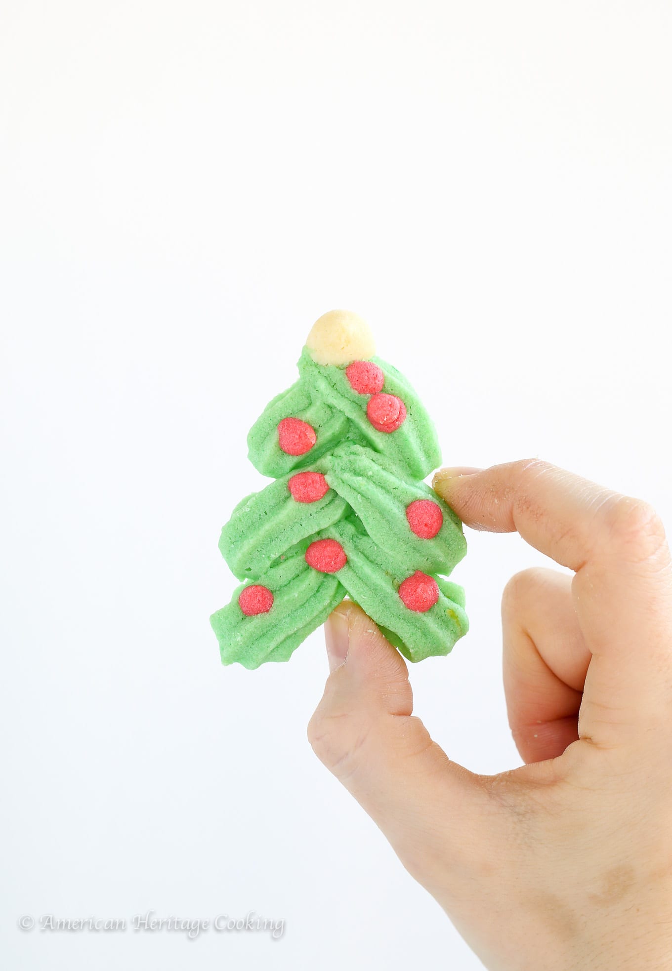 These festive Holiday Spritz Cookies are a light, delicate butter cookie flavored with vanilla and lemon. 