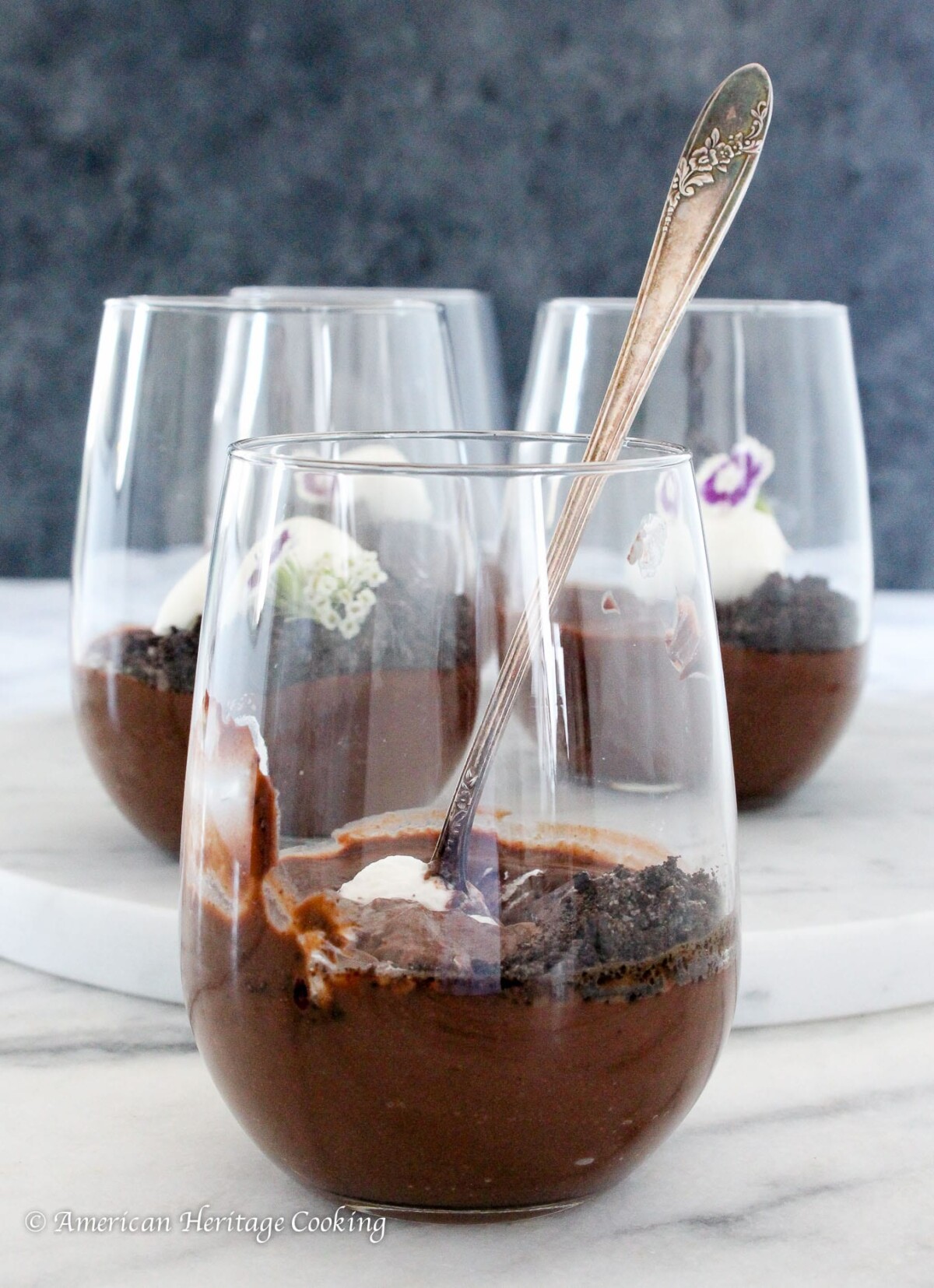 Three clear cups of dark chocolate pudding.