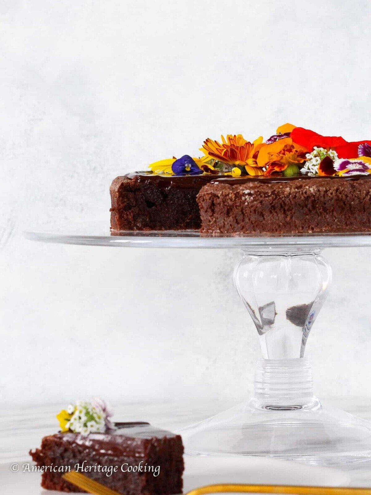 Flourless Chocolate Torte on a clear cake stand for Valentine's Day Desserts.