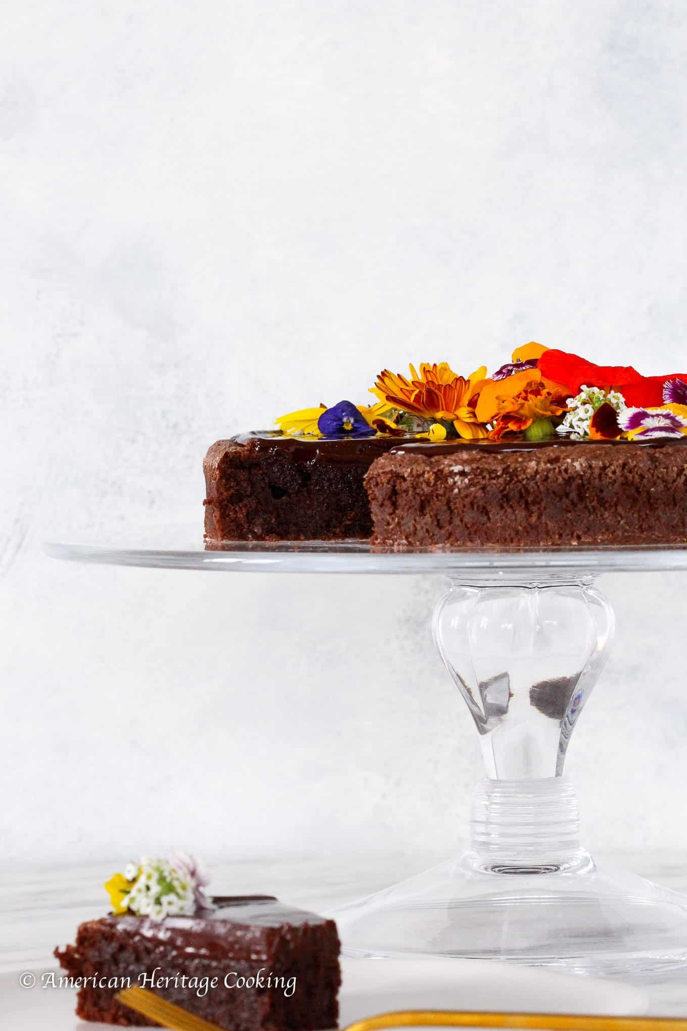 Hazelnut Flourless Chocolate Cake on a clear cake stand for Valentine's Day Desserts.