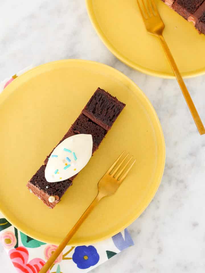 Devils Food Layer Cake slice on yellow plate with ice cream