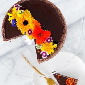 Hazelnut Flourless Chocolate Cake sliced with edible flowers.