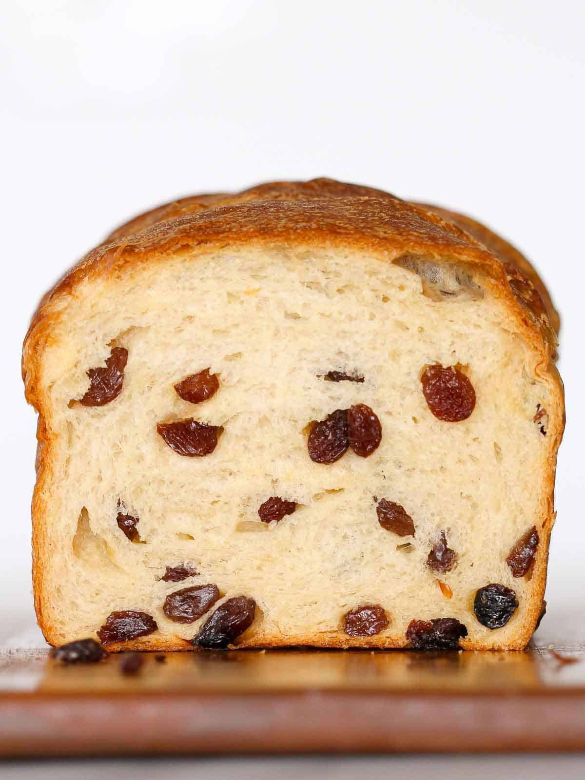 sliced sourdough raisin bread loaf against white background.