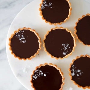 mini salted chocolate tarts on marble cake stand