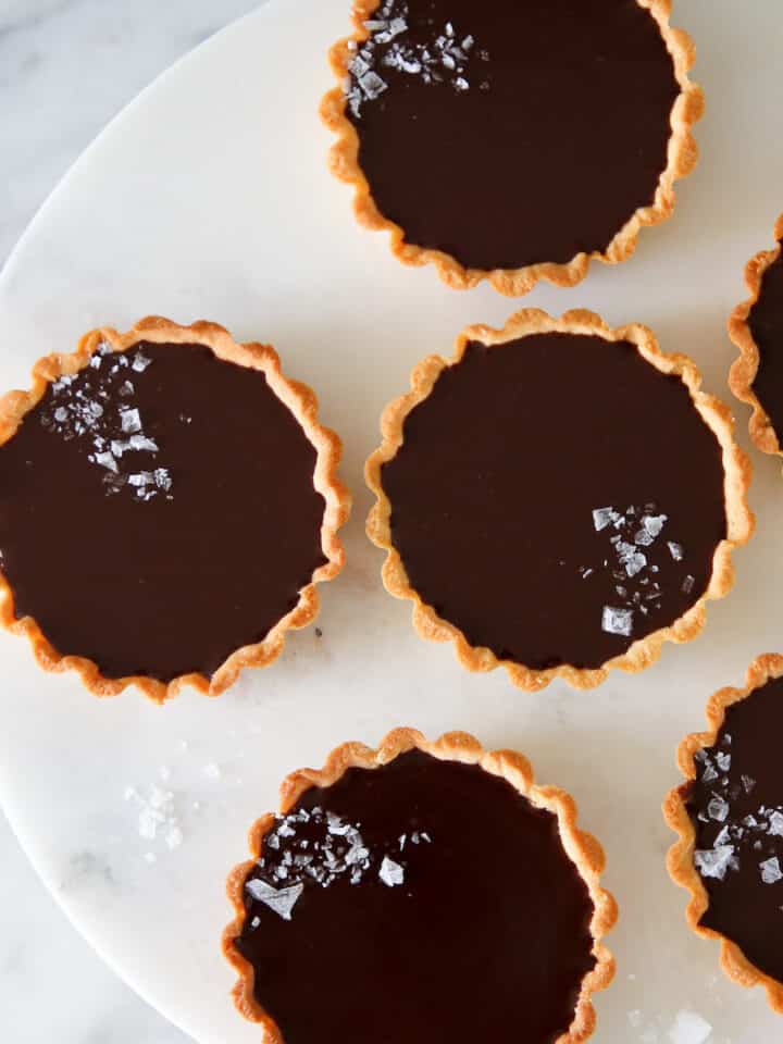 mini salted chocolate tarts on marble cake stand