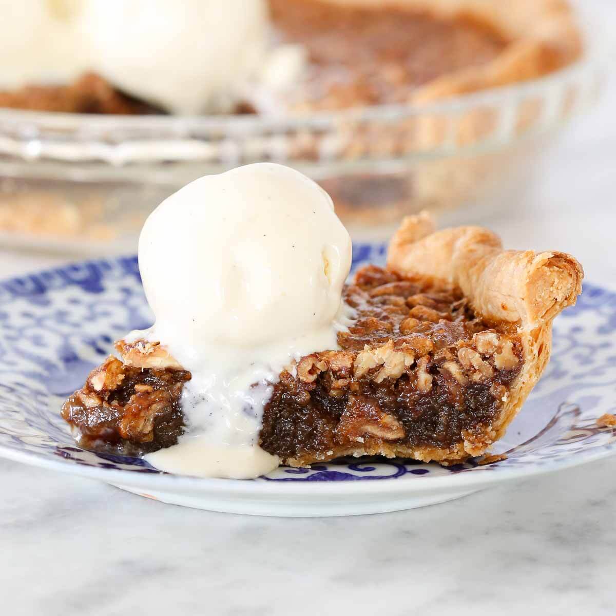 slice of bourbon pecan pie with ice cream scoop.