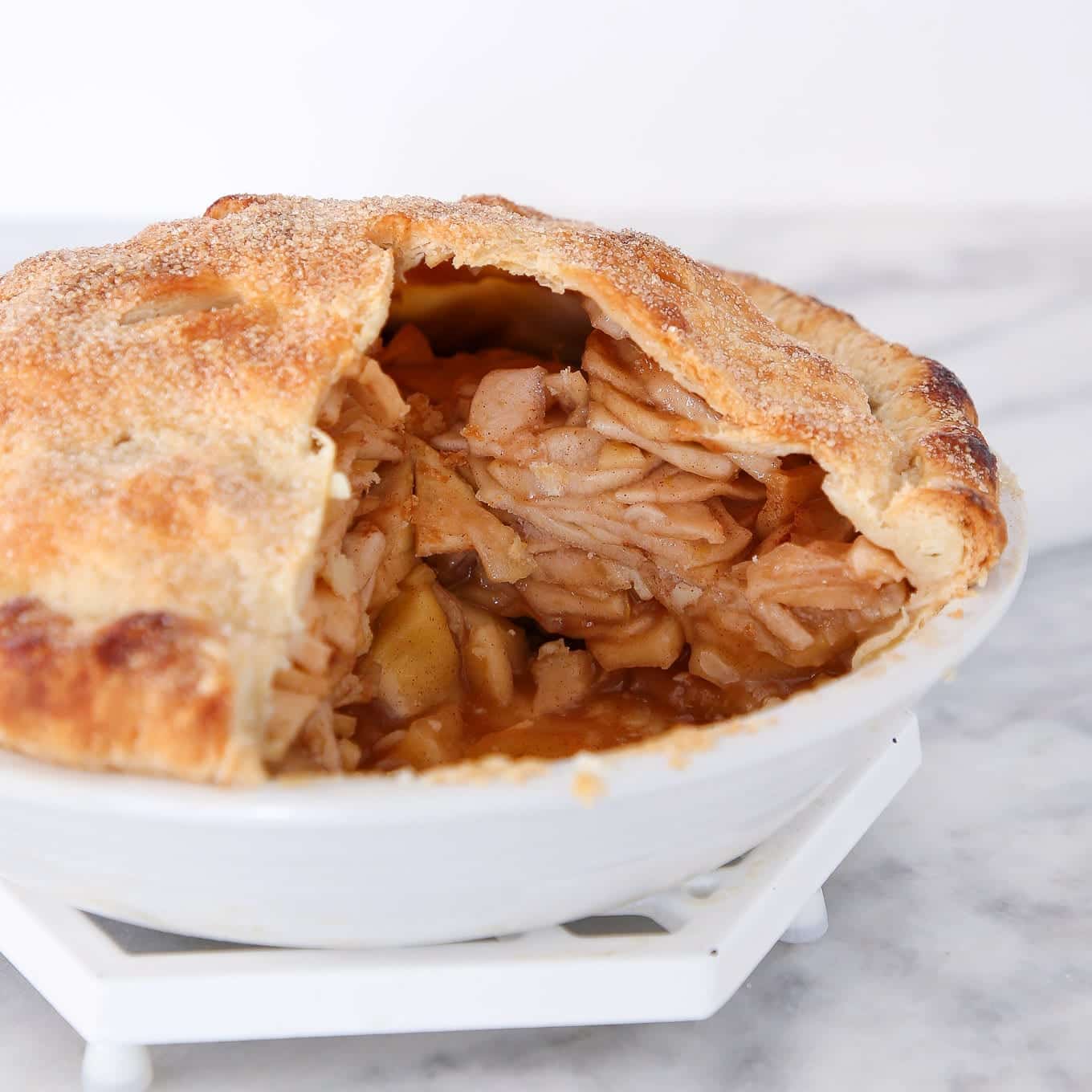 A whole apple pie with a slice removed.