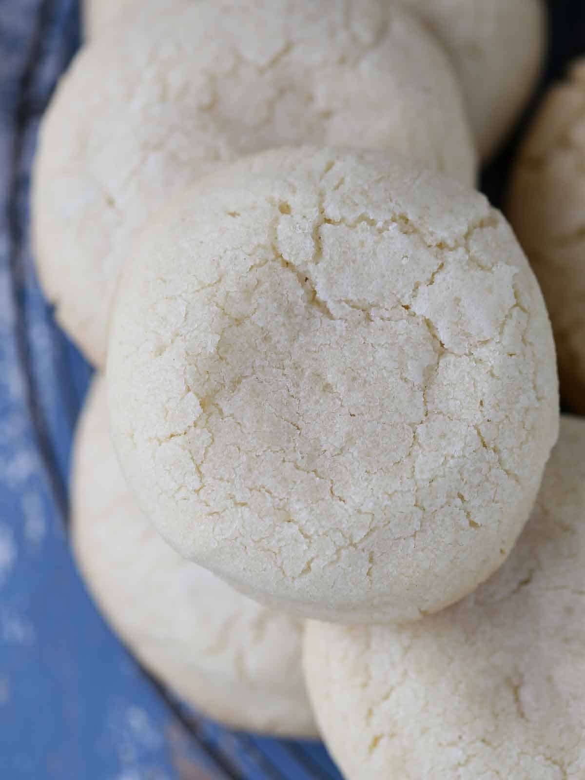 whole sugar cookies piled high on rack.