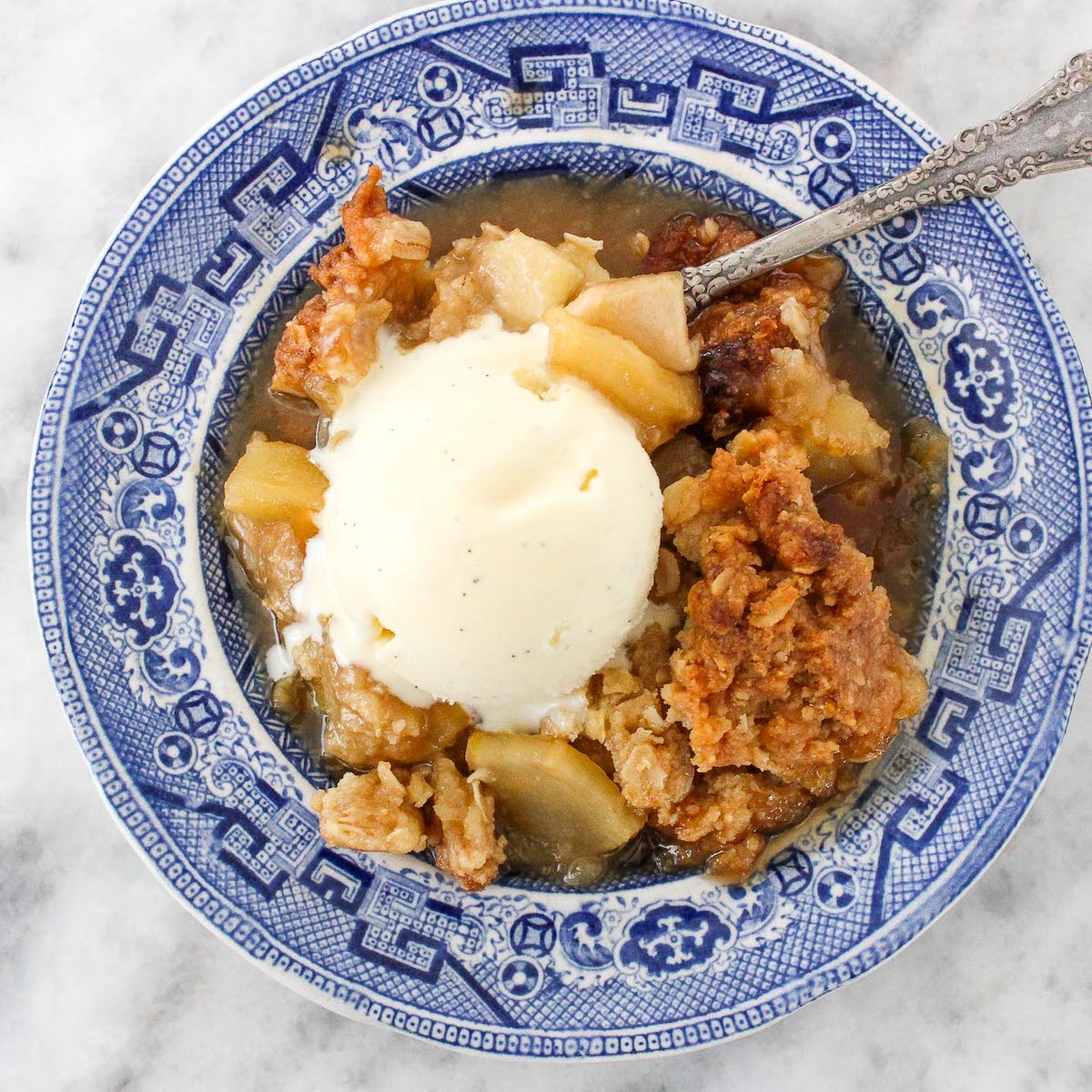 Classic Apple Crisp with Oat Streusel on plate with ice cream