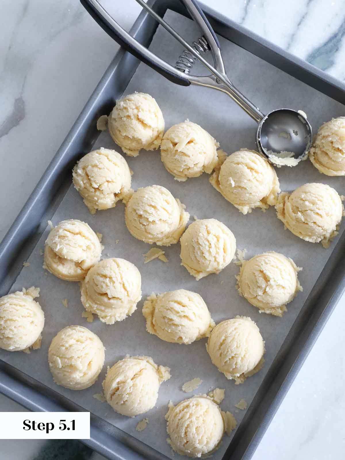 scooping sugar cookie dough on baking sheet.