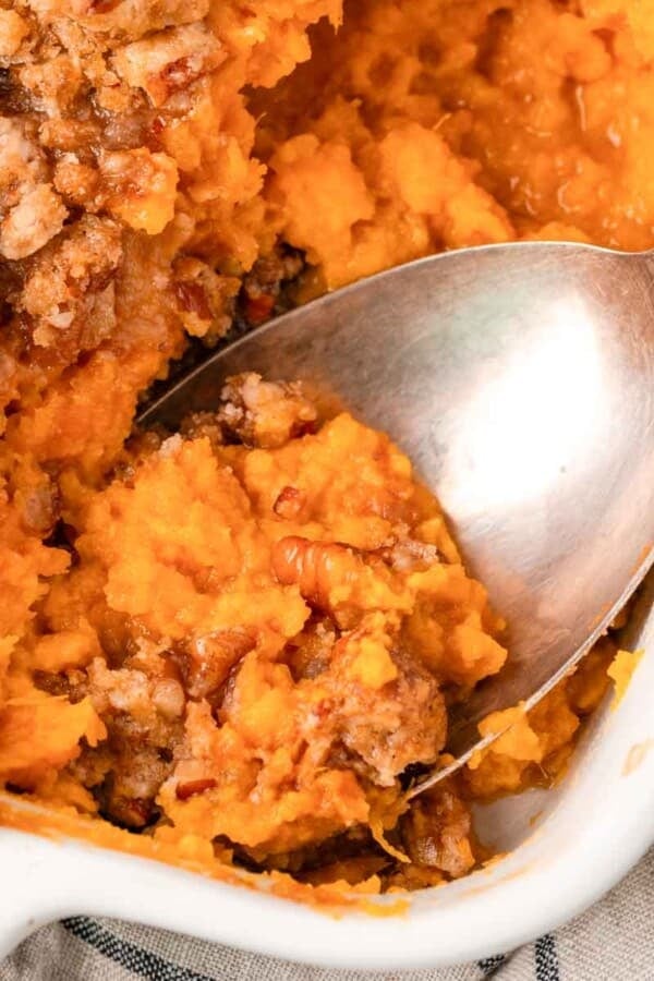 sweet potato casserole being served with spoon.