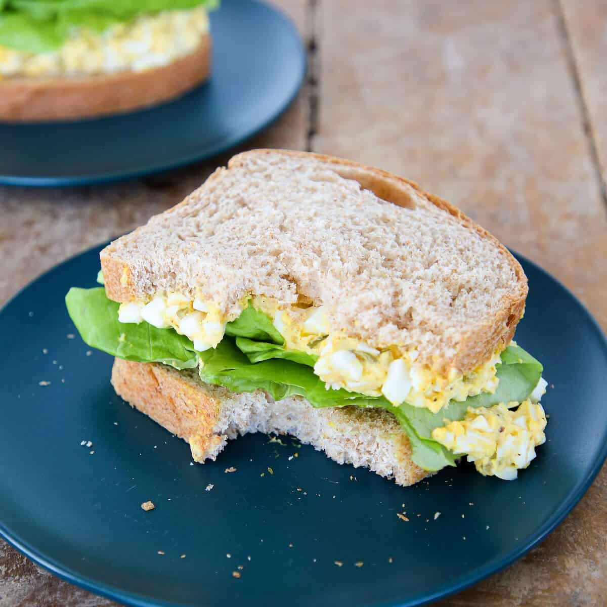 Deviled Egg Salad Sandwich bitten on green plate
