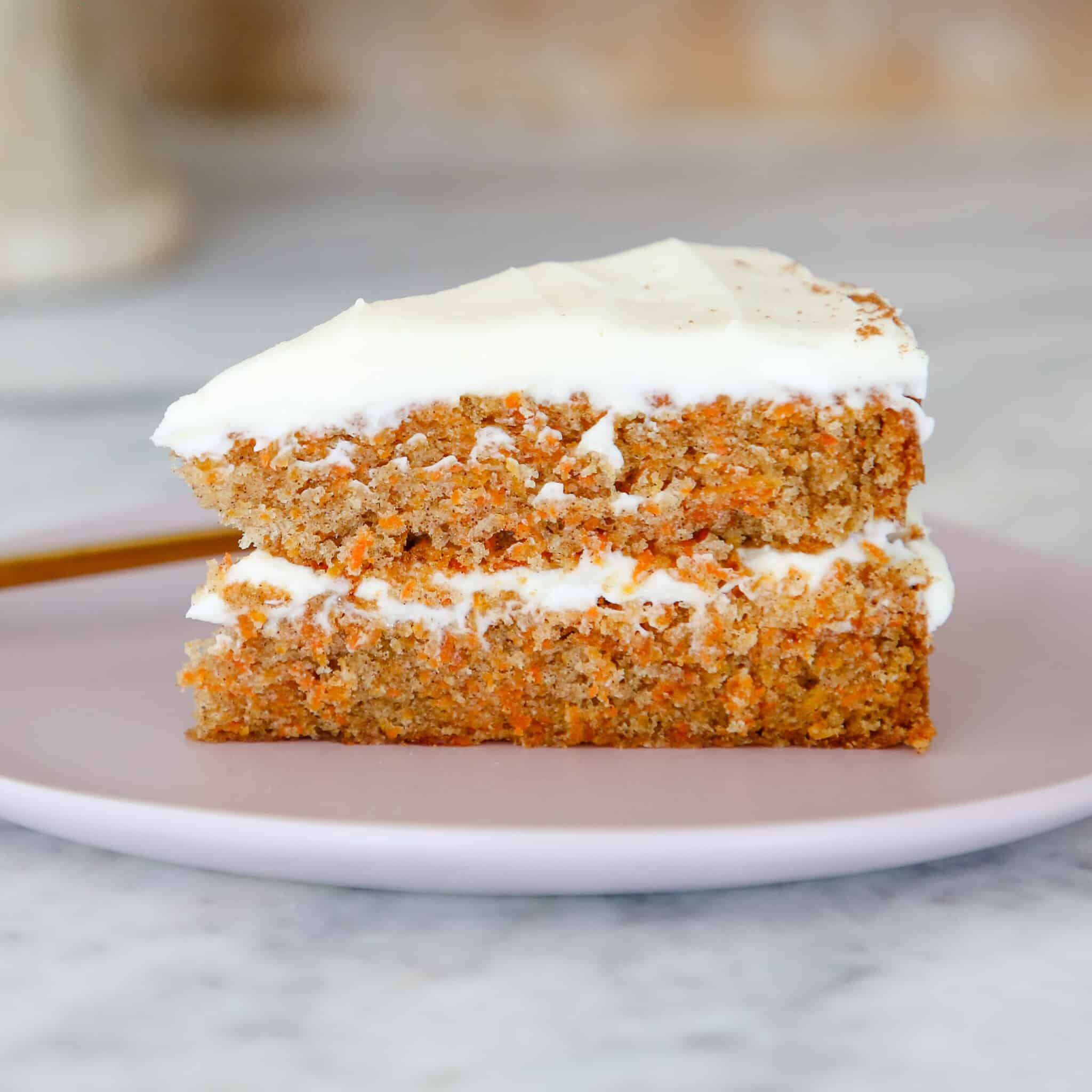 slice of carrot cake on pink plate. 