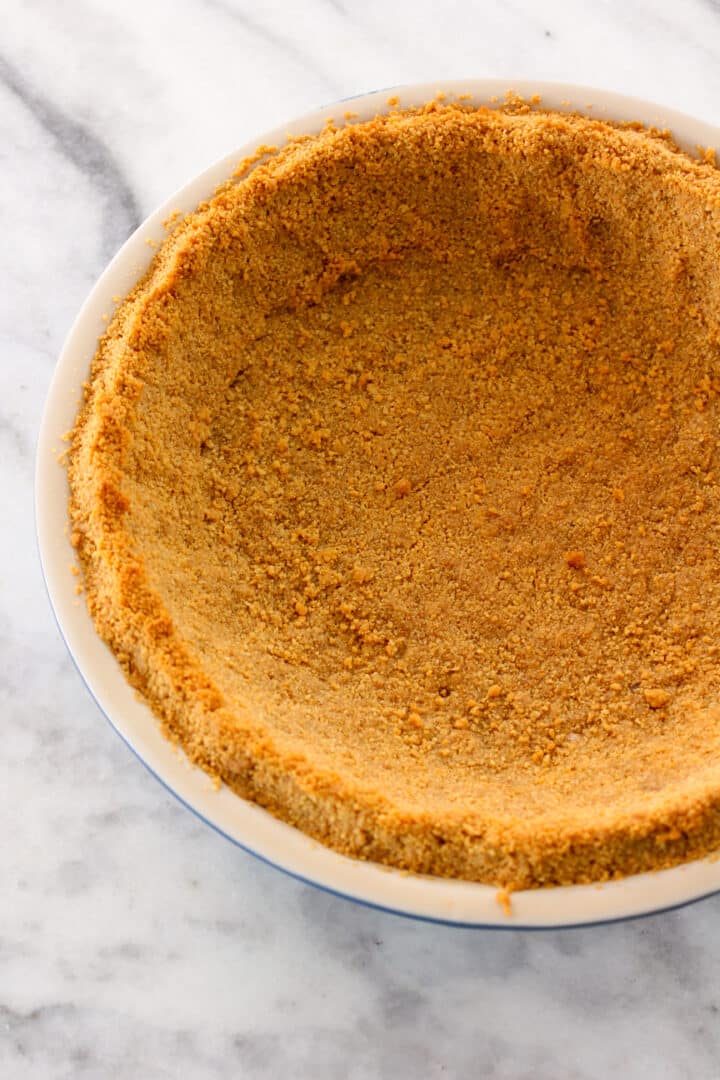 Baked Graham Cracker Crust on marble surface in pie dish