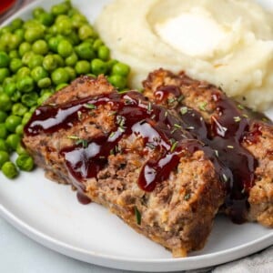brown sugar meatloaf on white plate with sauce.