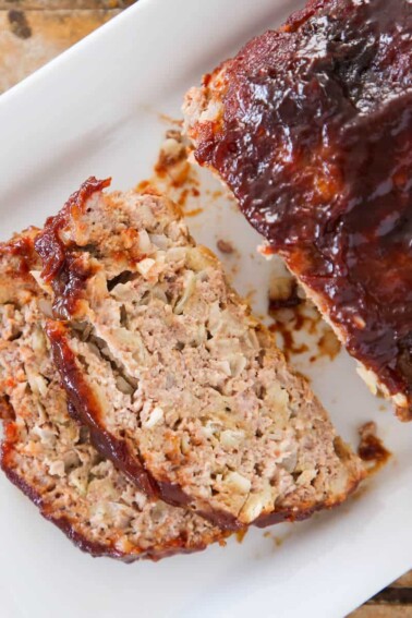 The best meatloaf sliced on white plate with perfectly cooked texture.