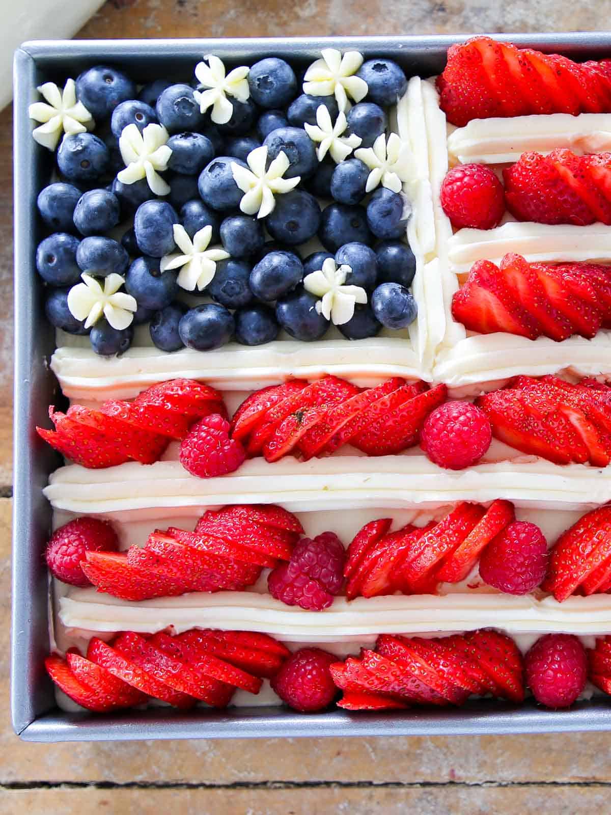 american flag cake with berries unsliced.