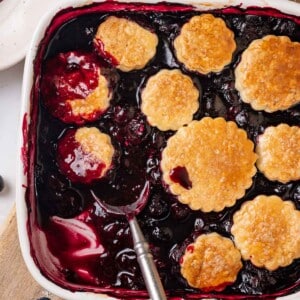 dished out blueberry cobbler in white baking dish.